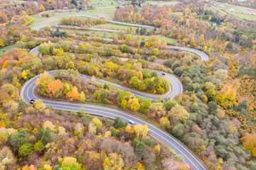 Cars drive curvy road in Wujskie, Poland, aerial view