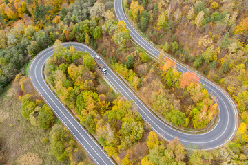Aerial view on curvy road amid colourful autumn forest in Bieszczady, Poland