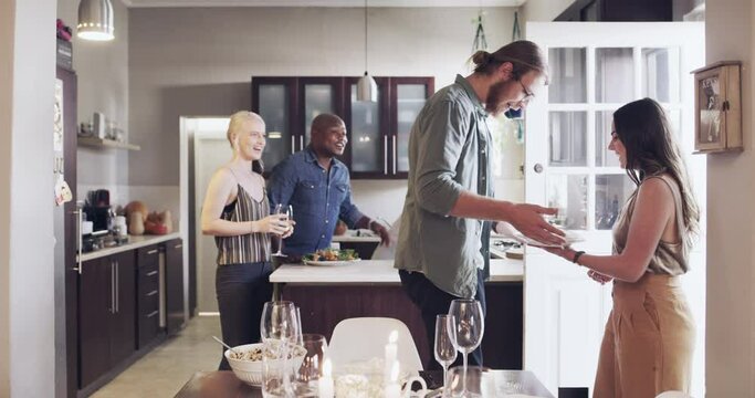 Friends, dinner and party with hello and celebration at house, group with hug and kiss for welcome and happy together. Men, women and food, friendship social time and celebrate birthday or holiday.