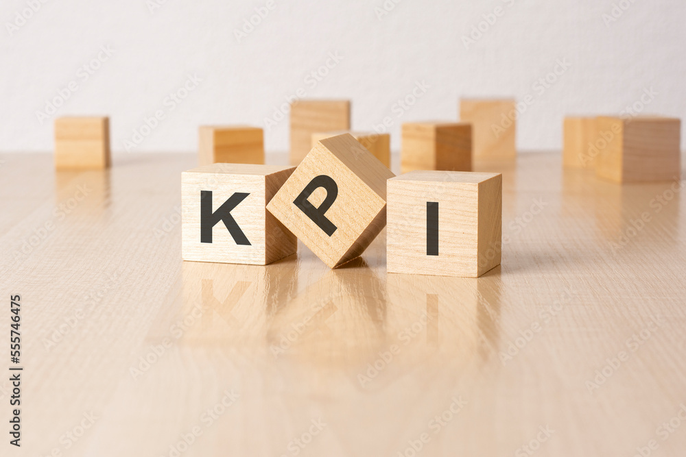 Aufkleber kpi - an abbreviation of wooden blocks with letters on a gray background. reflection caption on the 