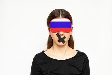 A girl with a blindfold in the color of the flag of Russia and a band-aid closed her mouth on a white background, a Russian girl does not see or hear, a deaf and dumb