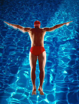 Back View of Man in Swimwear Diving into Swimming Pool