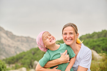 Nurse plays with her young cancer patient in the wilderness