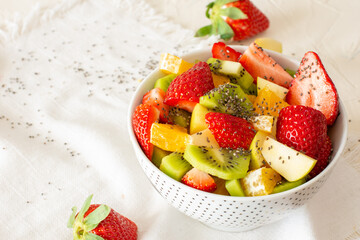 Bowl of healthy fresh fruit salad on white background. Top view