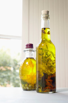 Still life of bottles of olive oil with herbs on window sill, Germany