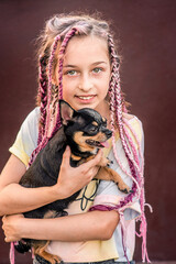 Obraz premium A teenage girl with a dog in her arms. The little girl had a pet chihuahua.