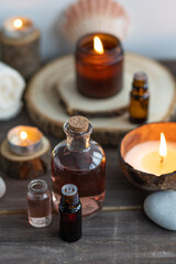 Concept of natural essential organic oils, Bali spa, beauty treatment, relax time. Atmosphere of relaxation, pleasure. Candles, towels, dark wooden background. Alternative oriental medicine