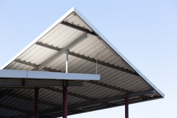 Obraz premium Die Ecke einer alten Dachkonstuktion aus Metall ragt in den blauen Himmel und bildet Dreiecke. 