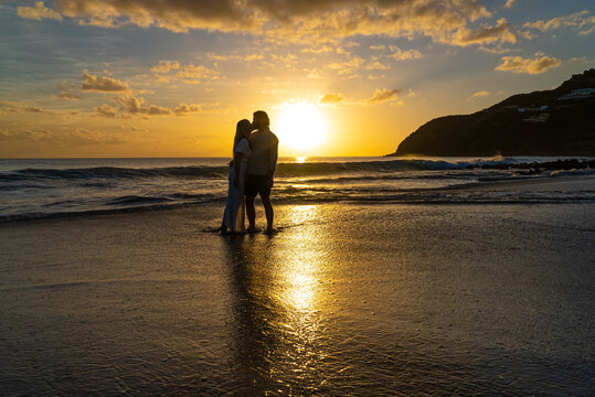 Silhouette of couple kissing during the sunset on a tropical sandy island beach