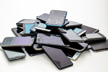 Viele defekte Smartphones liegen auf einem Stapel 