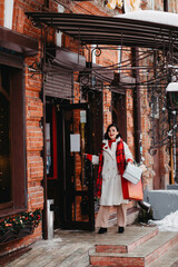 Fototapeta premium beautiful brunette with purchases and gifts for the family. winter city