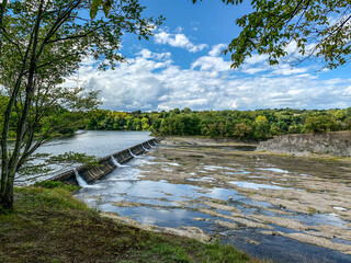 Fototapeta premium Water flowing over a dam on a river in New York State