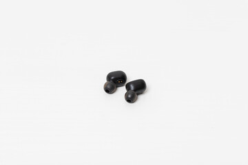 A set of rechargeable in-ear headphones. Isolated on white table.