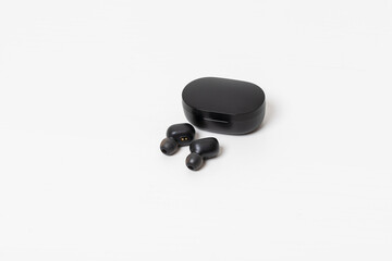 A set of rechargeable in-ear headphones. Isolated on white table.