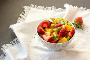 Bowl of healthy fresh fruit salad on white background. Top view