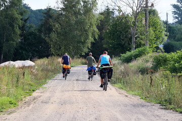 Ludzie na rowerach jadą polną drogą na wycieczkę.
