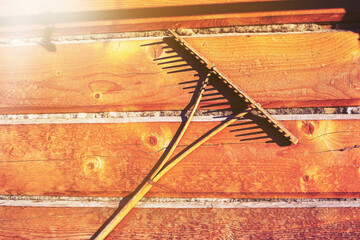 Wooden rake hanging on the wall of a log house.Old peasant tool.