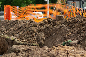 Excavated soil at construction site. Laying pipes in city. Excavated earth. Cable trench.