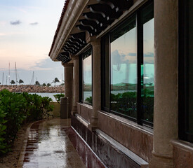 grandes fenêtres sur un bâtiment avec vue sur la mer lors d'une journée pluvieuse