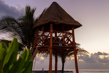 cabane au toit de paille en hauteur sur le bord de la plage lors d'un matin