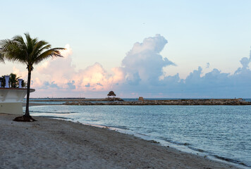 Lever de soleil sur la plage avec de gros nuages en arrière plan en bord d'océan