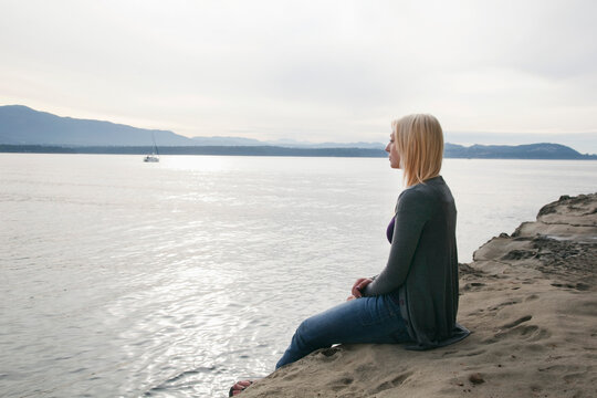 Woman Sitting on the Beach, Vancouver, BC, Canada