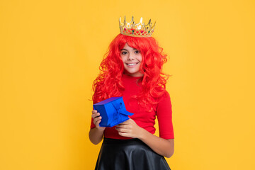 glad child in crown with present on yellow background