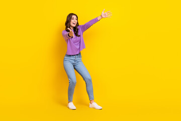 Fototapeta na wymiar Full body photo of astonished glad lady raise opened arms look empty space isolated on yellow color background