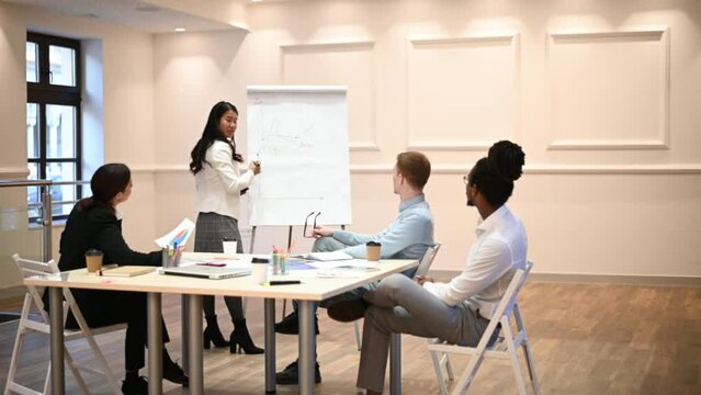 Asian woman business leader drawing chart on a flipchart board and holding a meeting
