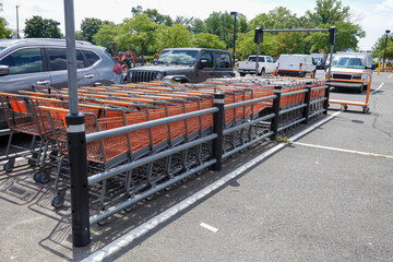 Corral full of orange shopping carts in a parking lot