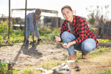 Woman planting young seeds in her organic plantation