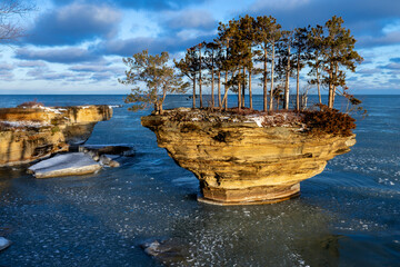 Morning sun lights up a rock formation on Lake Huron. Locally known as Turnip Rock, it is a popular destination for kayakers during the summer season. Pancake ice begins to form.