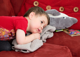 cute boy watching tv on the couch with face in strawberry juice