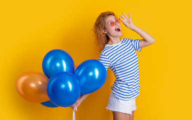 party girl with balloon in sunglasses. surprised girl hold party balloons in studio.