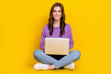 Naklejka premium Full body portrait of cheerful nice lady sit floor use wireless netbook isolated on yellow color background