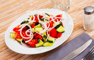 Delicious vegetable salad with tomato, cucumber and onion on plate