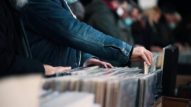 Close-up of a man hands choosing a vinyl at the vinyl market.