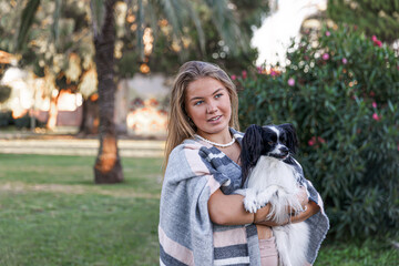 A girl plays with a dog in the park