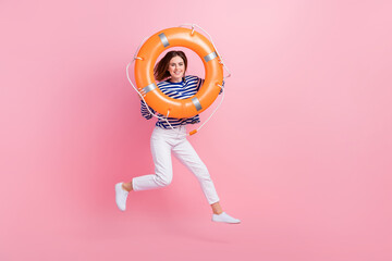 Full size photo of excited crazy girl jumping hands hold inflatable ring isolated on pink color background