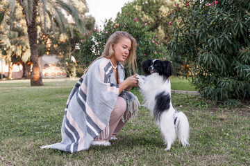 Naklejka na ściany i meble A girl plays with a dog in the park