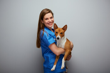 Smiling veterinarian doctor holding dog Isolated portrait. - 555770410