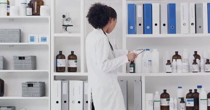 Checklist, black woman and scientist with medicine writing drugs report for research in a science laboratory. Pharmaceutical, clipboard and healthcare worker checking medical bottles stock inventory