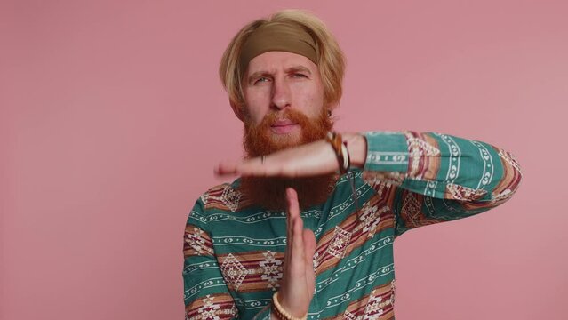 Tired serious upset hippie redhead bearded man in pattern shirt showing time out gesture, limit or stop sign, no pressure, i need more time, break, pause. Hipster ginger guy on pink studio background