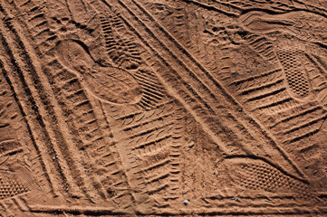 Footprints and wheel tracks in the sand