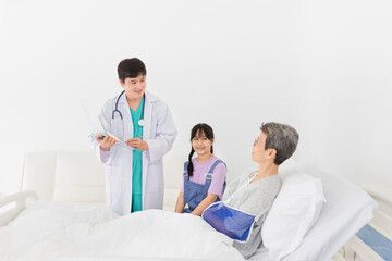 Obraz premium asian doctor talk with old patient in hospital, he screening and write patient information on patient chart, elderly healthcare treatment