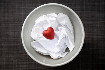 Heart shaped decoration with cruled paper in wastebasket