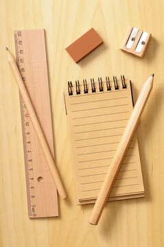 notebook, ruler and pencils on wooden background, studio shot