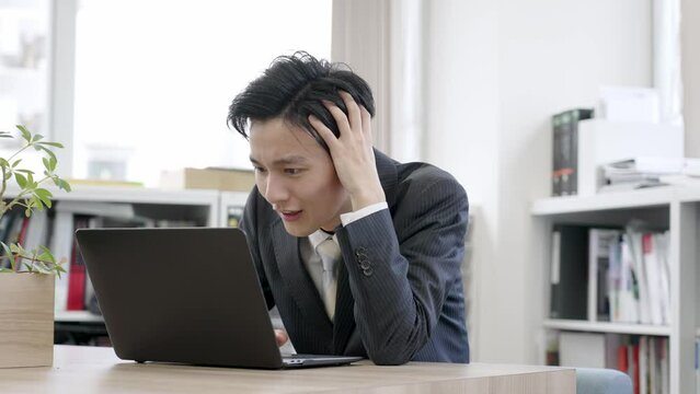 オフィスで頭を抱えるビジネスマン