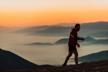 Obraz premium A man running on a mountain in the early morning as the sun rises