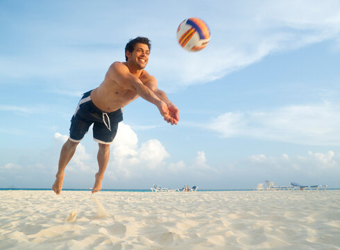 Man Playing Volleyball on Beach, Mexico